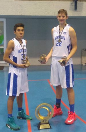 Andres Matute holding trophies and wearing a medal